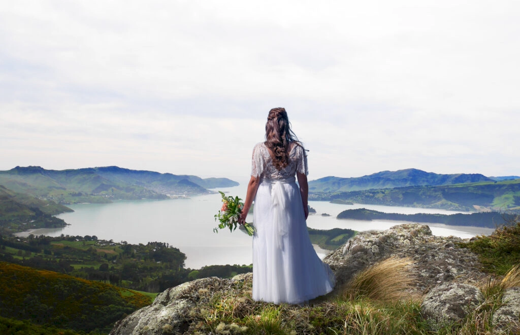 Bride stood at wedding destination Sign of the Bellbird, Port Hills, New Zealand.