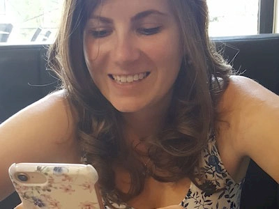 Pictured: Zoe holding her mobile phone and smiling