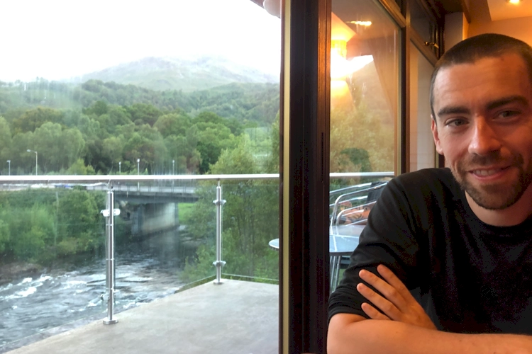 Stew in highland getaway waiting for dinner. Beautiful river views behind him.