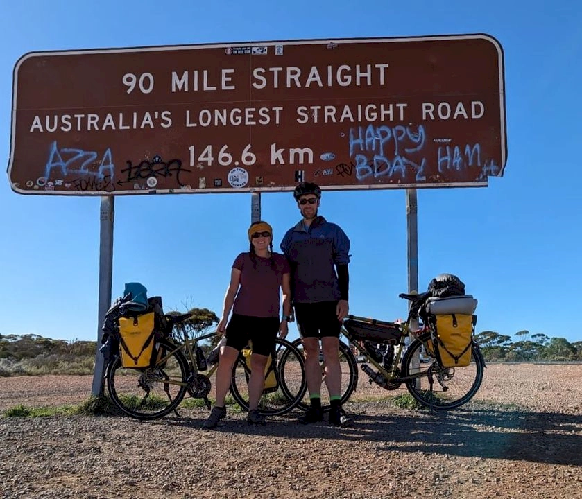 Zoe and Stew stood at the 90 Mile Straight sign across Nullarbor Plain