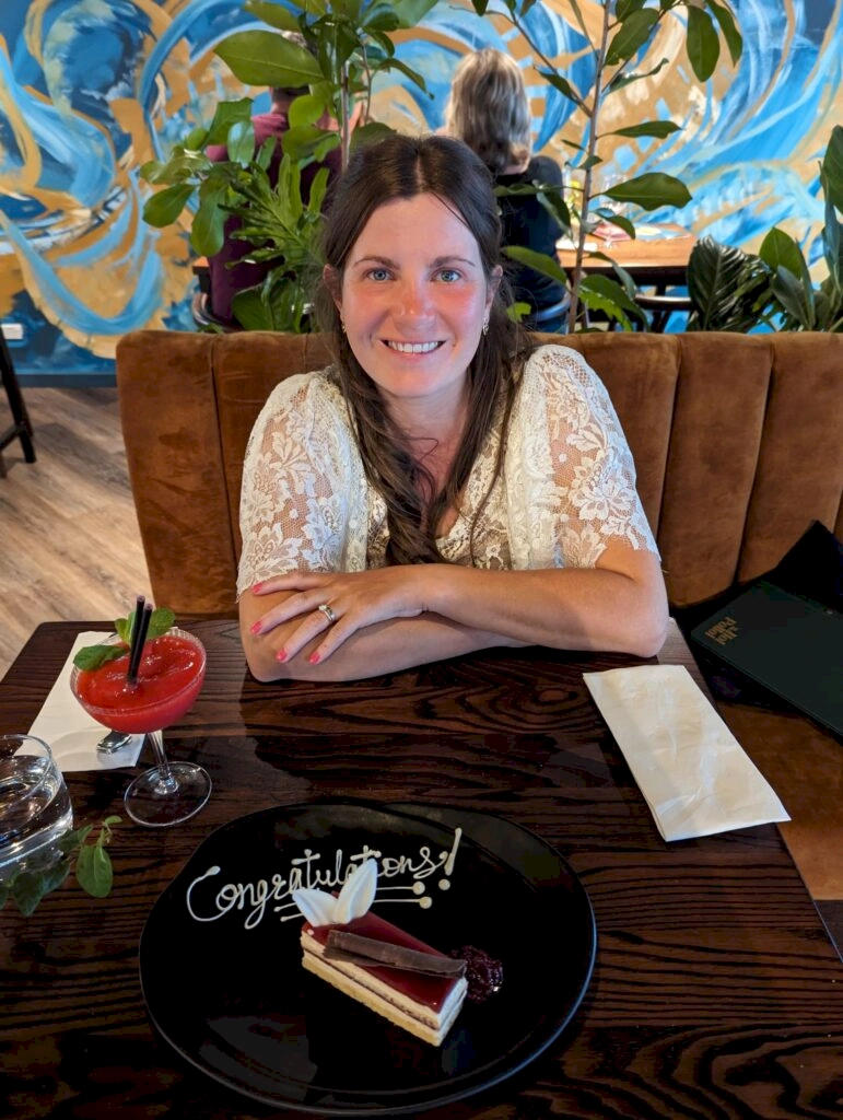 Zoe sat in Carnmore hotel with a celebratory cake and cocktail provided by the staff to celebrate the wedding elopement.